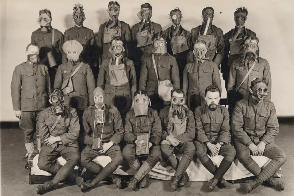 Soldats présentant différents modèles de masques à gaz en 1919