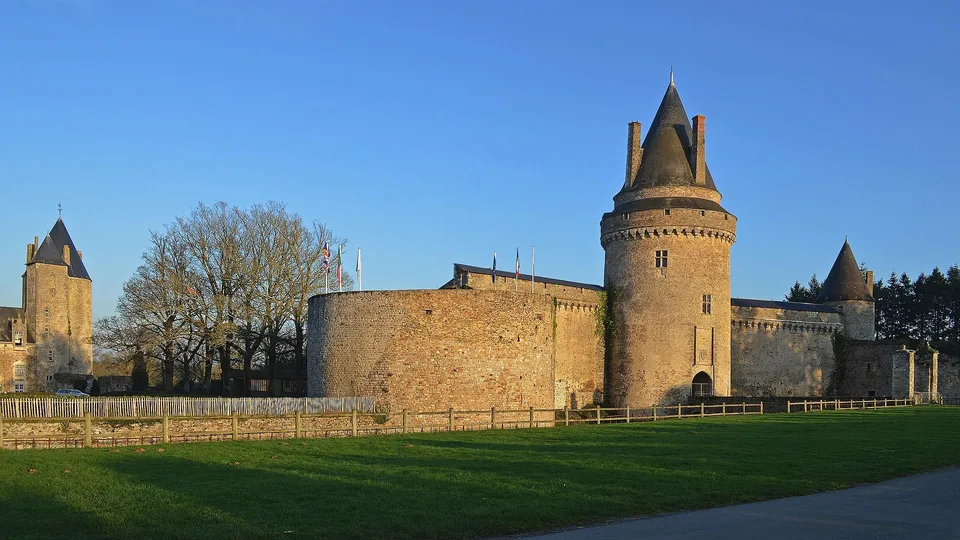 Mur d’enceinte et tour circulaire du château de Blain sous un ciel dégagé