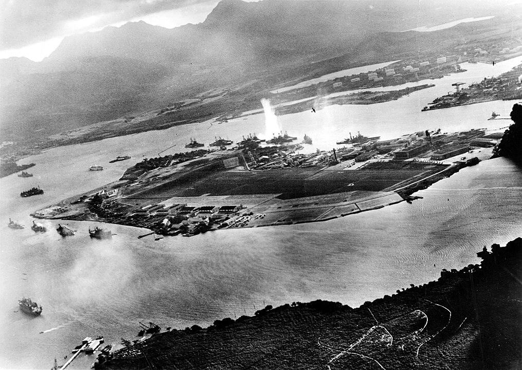 Attaque japonaise sur Pearl Harbor vue depuis un avion, avec l’USS West Virginia touché par une torpille près de l’île Ford.