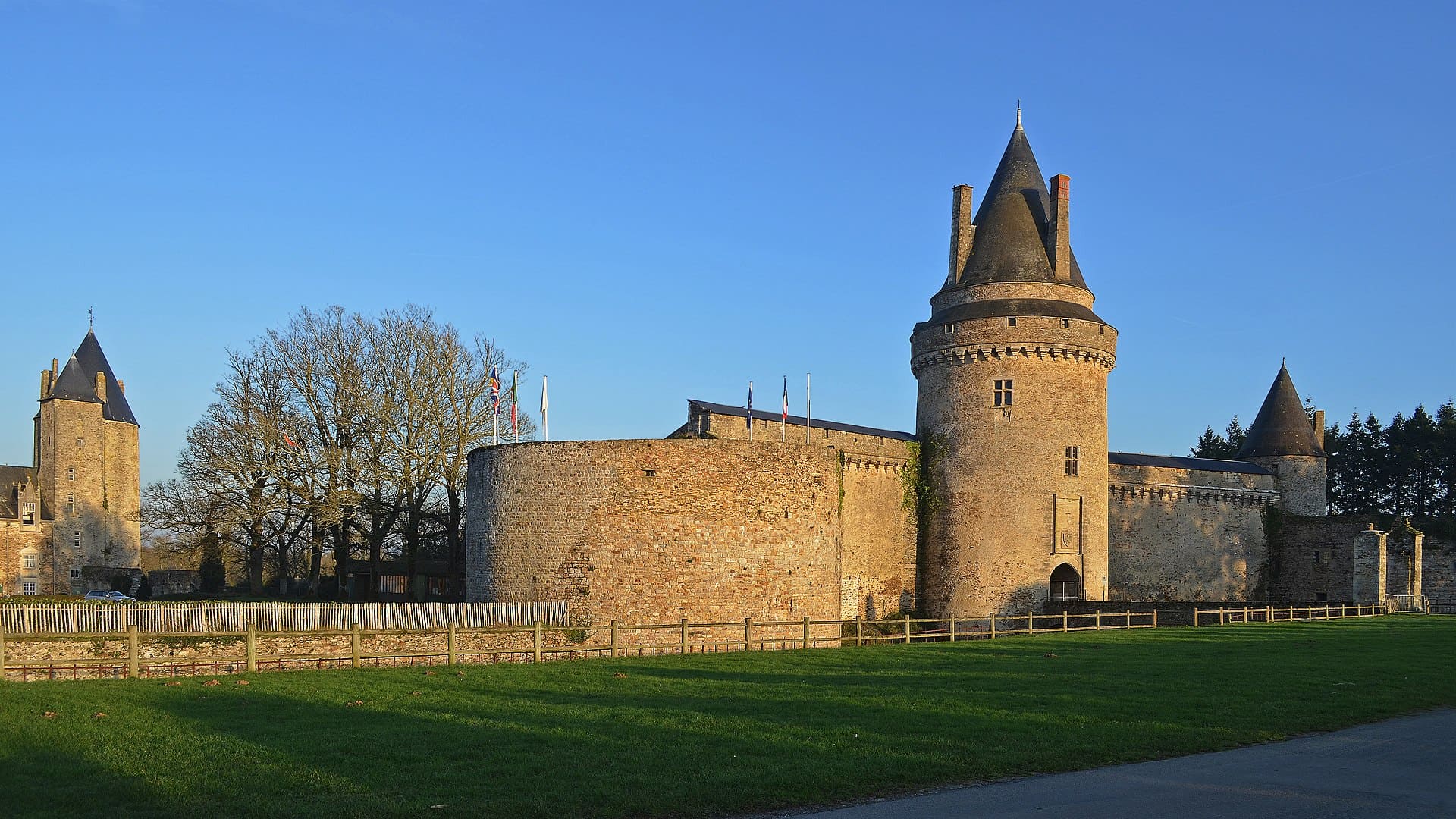 Mur d’enceinte et tour circulaire du château de Blain sous un ciel dégagé
