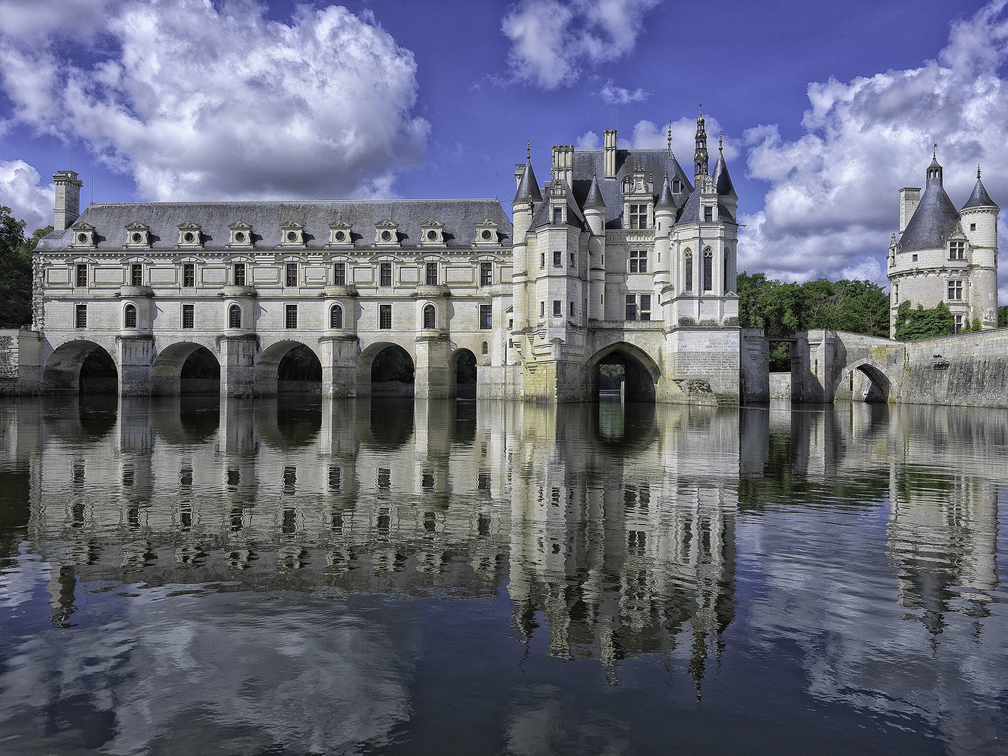 Château de Chenonceau enjambant le Cher, avec sa galerie et ses arches reflétées dans l’eau