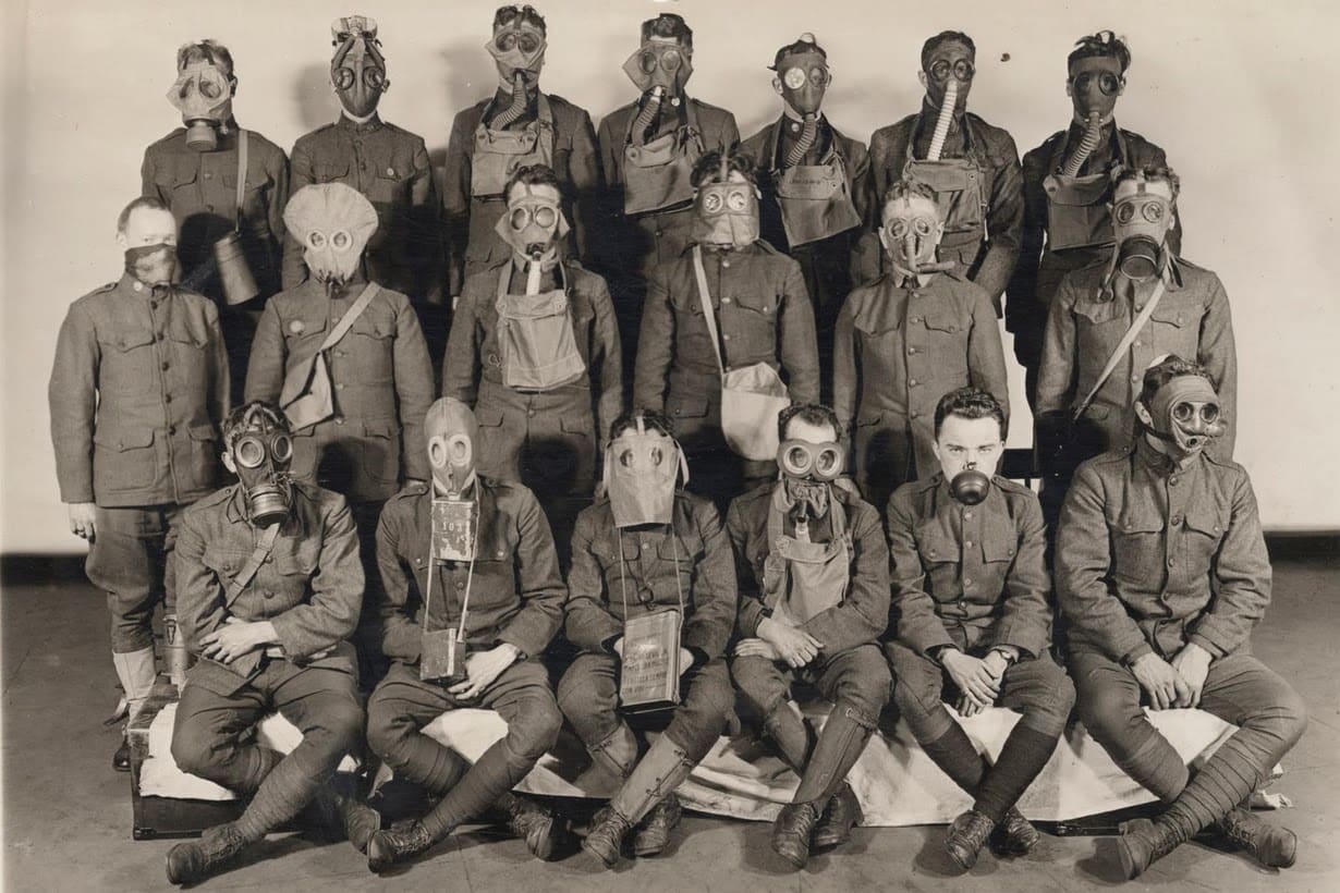 Soldats présentant différents modèles de masques à gaz en 1919